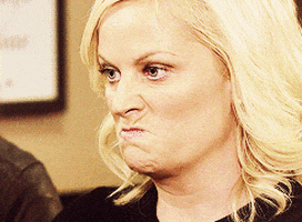 Leslie Knope from Parks and Recreation TV show, scrunching her nose and making a angry and frustrated type face