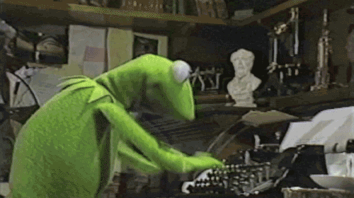 A GIF of Kermit the Frog, a green frog hand puppet, typing furiously at his typewriter. 